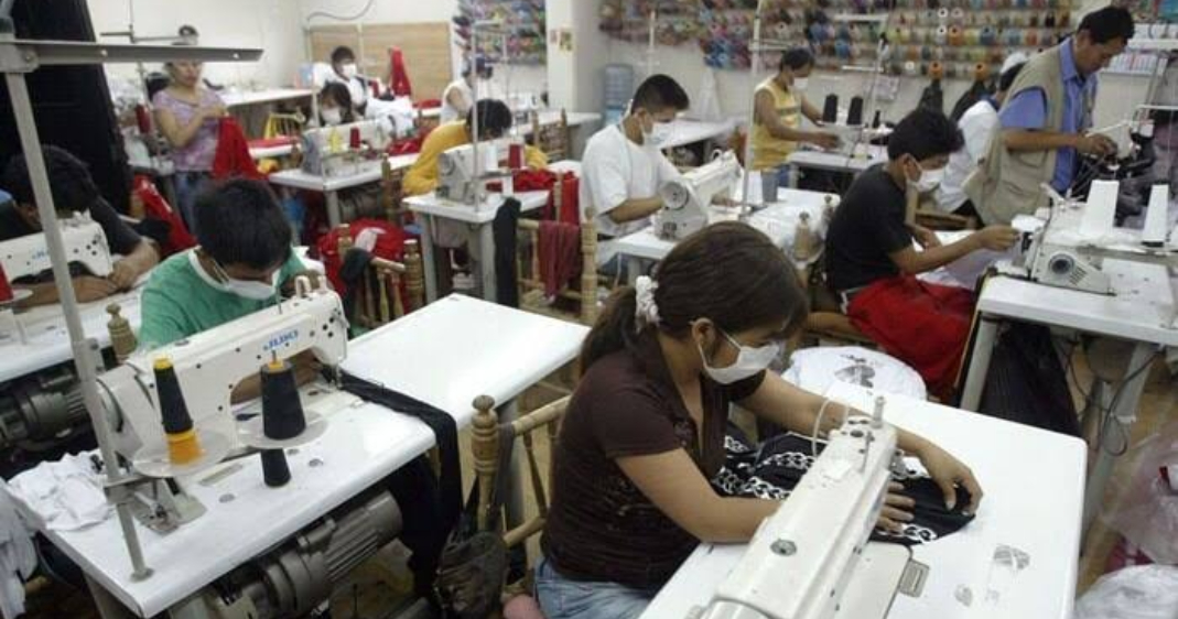 Proveedor textil, trabajadores laborando en una máquina de coser.